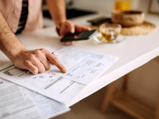 hands pointing at sheet and holding mobile