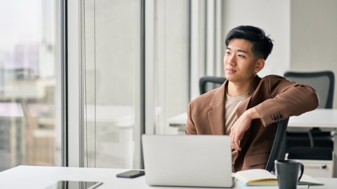man behind desk with laptop image