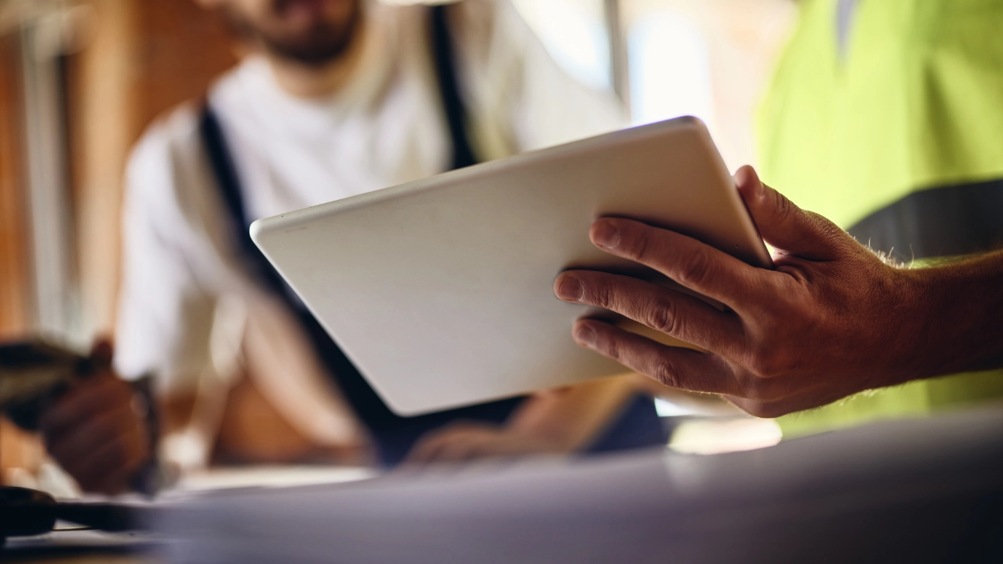 Two workers holding a tablet in a meeting on site image