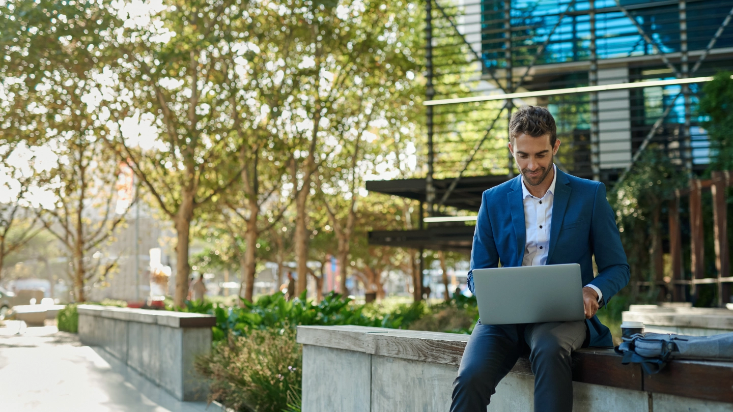 young businessman working online with laptop sitting outside young businessman working online with laptop sitting outside