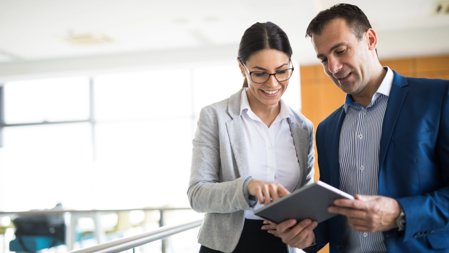 Two business people discussing business strategy using a tablet Two business people discussing business strategy using a tablet