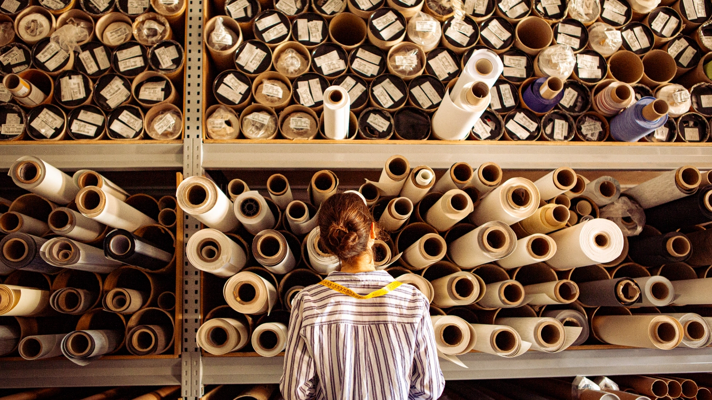 Female textile worker examining reels of fabric image